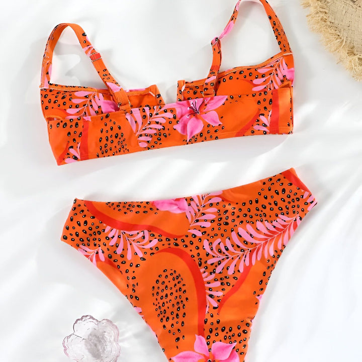 Vue arrière d'une femme portant un bikini taille haute à motif floral orange et rose. Le haut est un modèle à fines bretelles ajustables.