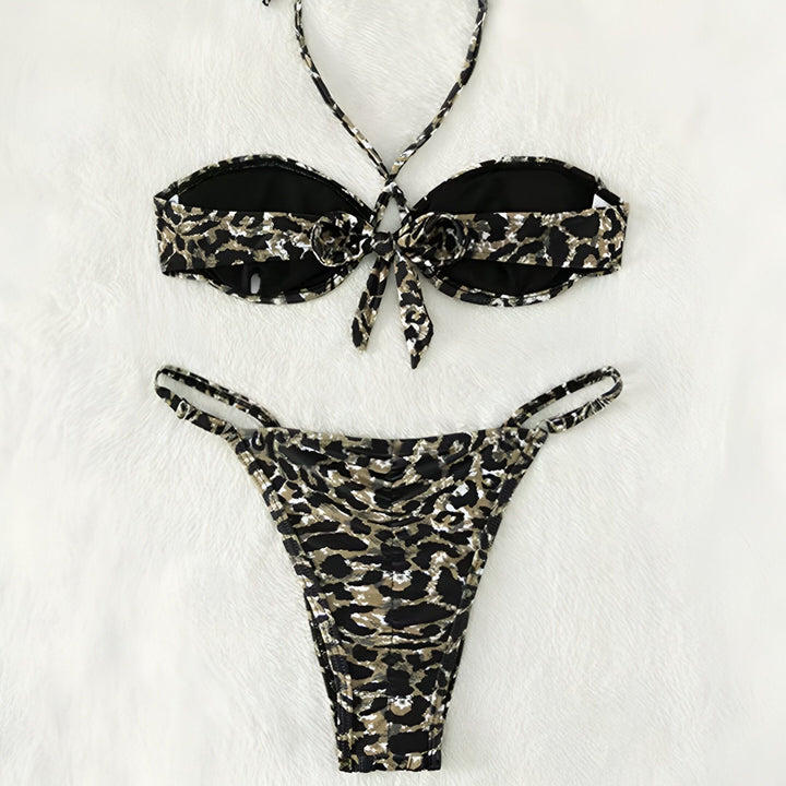 Maillot de bain deux pièces imprimé léopard : haut bandeau avec bretelles croisées et bas échancré. Mode été, tenue de plage tendance.