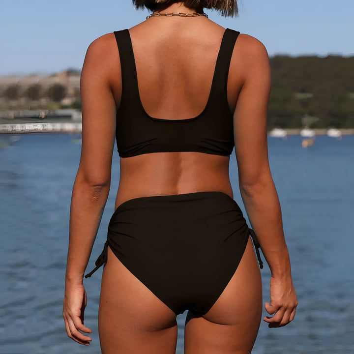 Maillot de bain deux pièces noir pour femmes, haut croisé et culotte taille haute avec cordons de serrage sur les côtés. Idéal pour la plage ou la piscine.