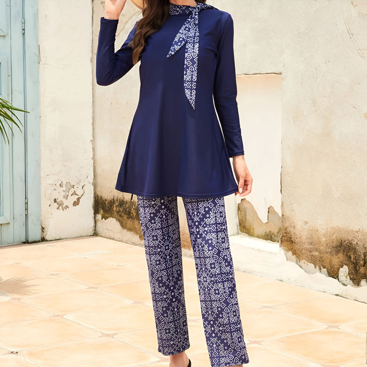 Femme souriante portant un burkini bleu marine avec un foulard à motifs. Vêtements de bain islamiques à manches longues et modestes, idéals pour la plage et la piscine. Mode pudique et élégante.