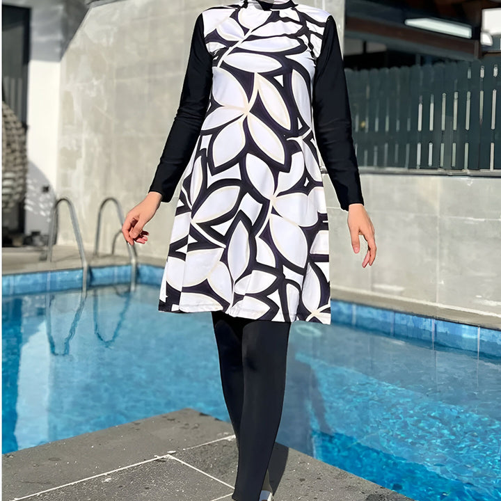 Femme en burkini moderne, lunettes de soleil et hijab près de la piscine. Maillot de bain couvrant à motifs floraux. Mode de bain pudique et élégante. Vêtements de bain islamiques.
