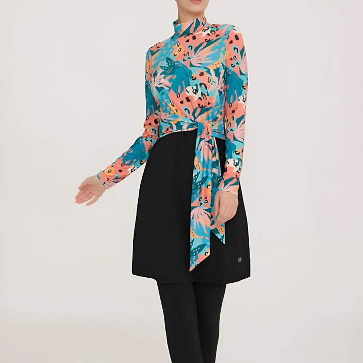 Maillot de bain modeste pour femme, haut à manches longues à motifs floraux multicolores, jupe et legging noirs, look tendance et confortable pour la baignade.