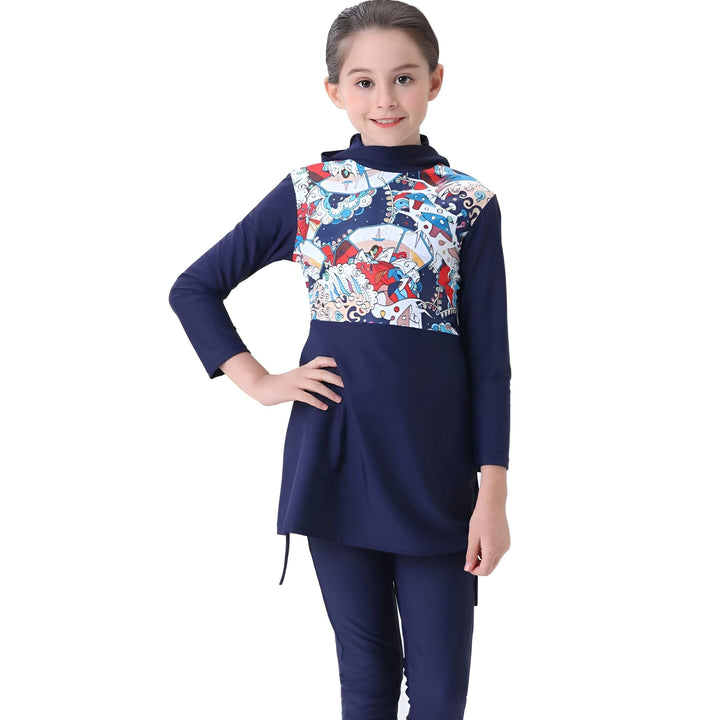 Jeune fille souriante portant un maillot de bain burkini bleu marine avec un motif imprimé sur le haut. Tenue de bain islamique pour enfants. Mode pudique.
