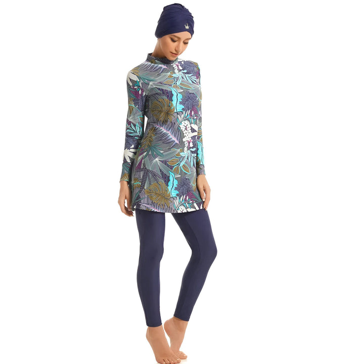 Femme portant un burkini à motifs floraux et un bonnet de bain bleu marine. Vêtement de bain islamique couvrant tout le corps. Mode pudique pour la plage et la piscine. Burkini moderne et élégant.