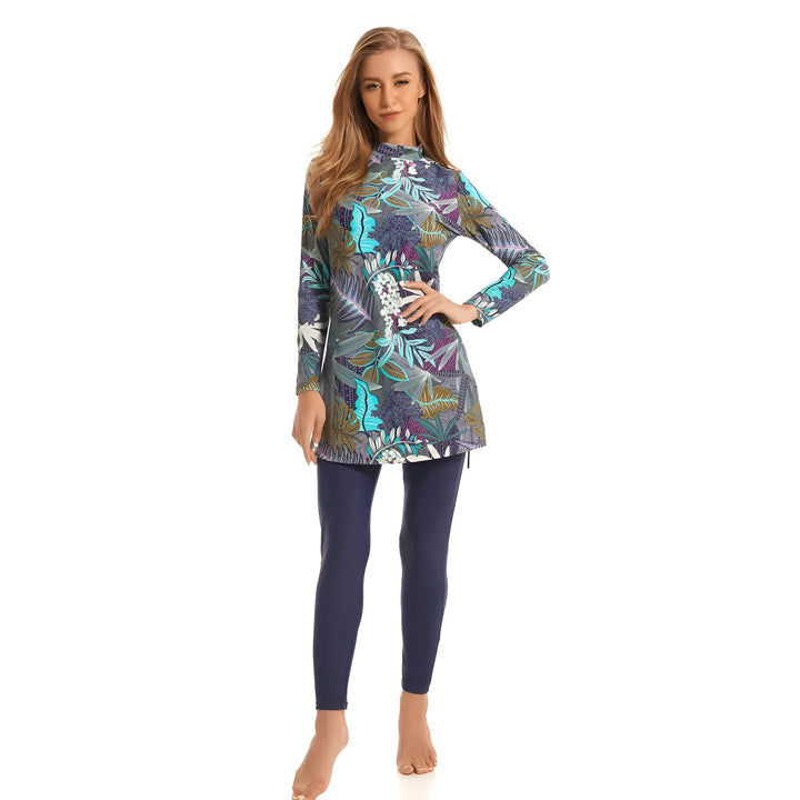 Femme portant un burkini imprimé floral avec un bonnet de bain bleu marine. Vêtement de bain intégral pour femme musulmane. Mode islamique pour la natation. Burkini moderne et élégant.