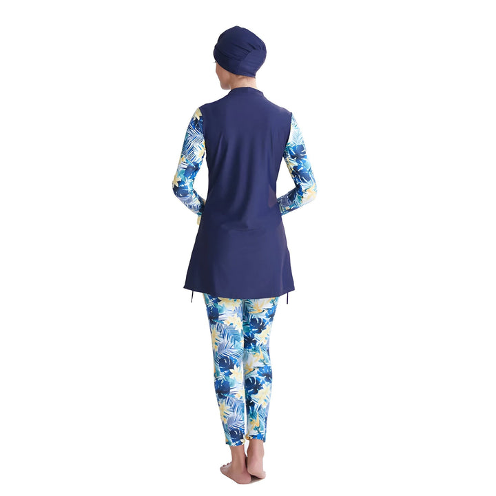 Femme portant un burkini bleu marine avec un imprimé floral bleu et jaune, comprenant un hijab, un haut à manches longues et un legging. Vêtements de bain modestes pour femmes musulmanes. Mode islamique.