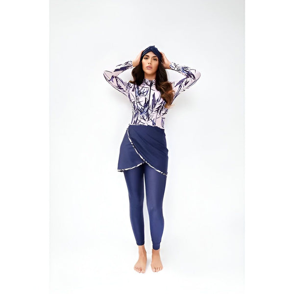 Femme portant un maillot de bain modeste noir avec un hijab et une jupe portefeuille assortie. Ses longs cheveux ondulés sont lâchés et elle pose les mains derrière la tête.