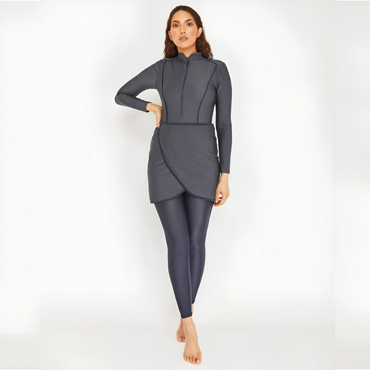 Femme portant un maillot de bain burkini gris à manches longues avec un leggings assorti. Vêtement de bain couvrant pour femmes musulmanes. Mode pudique. Vêtements de plage modestes.
