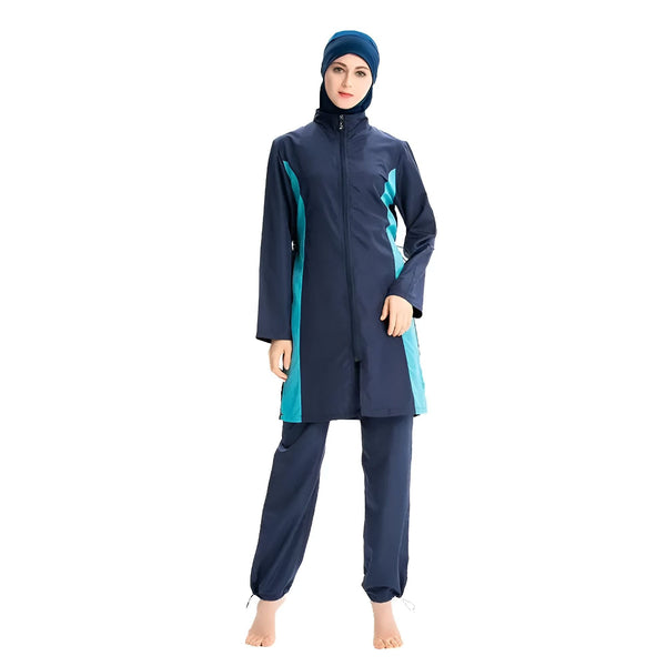 Une femme portant un burkini bleu marine et turquoise, un maillot de bain couvrant pour les femmes musulmanes. Elle porte un hijab assorti.