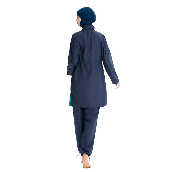 Femme portant un maillot de bain burkini bleu marine avec un hijab assorti. Vêtement de bain islamique, mode modeste.