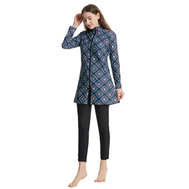 Femme portant un burkini à motifs géométriques, avec un bonnet assorti à la main. Vêtement de bain couvrant, noir en bas. Mode pudique pour la plage et la piscine.