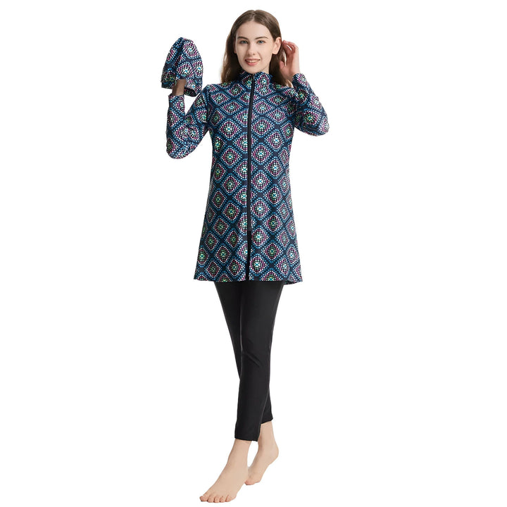 Femme portant un maillot de bain intégral bleu à motifs géométriques et un legging noir. Vêtement de bain couvrant pour femme. Mode pudique.