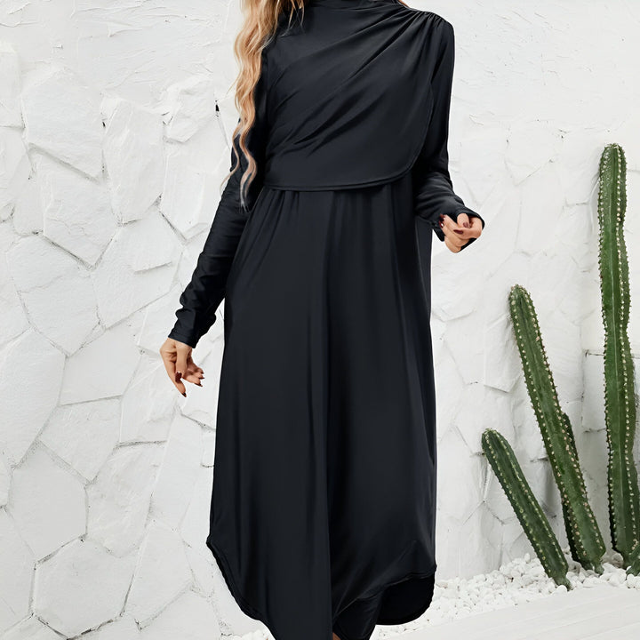 Femme portant un ensemble de loungewear moderne noir avec tunique à col drapé et pantalon fuselé. Vue de face et de dos.