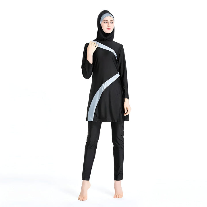 Femme portant un burkini noir avec des accents rouges, hijab assorti. Vêtement de bain couvrant pour femmes musulmanes. Mode pudique, maillot de bain intégral.
