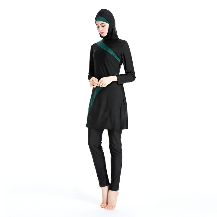 Femme portant un burkini noir et vert, costume de bain intégral avec hijab, manches longues, pantalon et tunique. Mode pudique. Vêtements de plage islamiques.