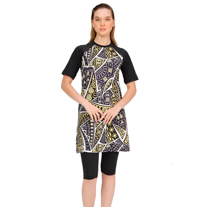 Vue arrière d'une femme portant un maillot de bain modeste noir avec un imprimé jaune et noir d'inspiration tribale, composé d'un haut à manches courtes et d'un legging court.