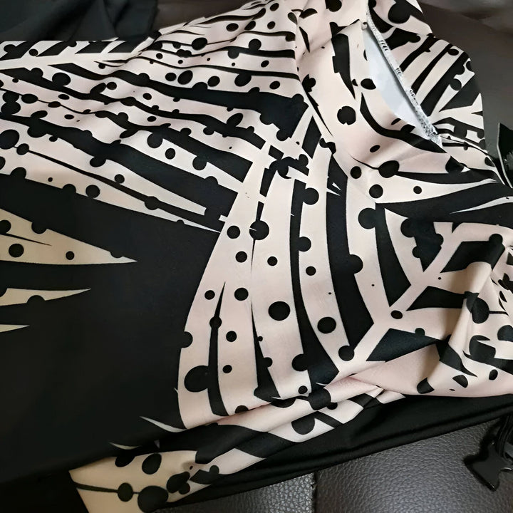 Gros plan d'un vêtement imprimé noir et blanc. Motif de rayures et de points. Tissu froissé. Mode, style, textile.