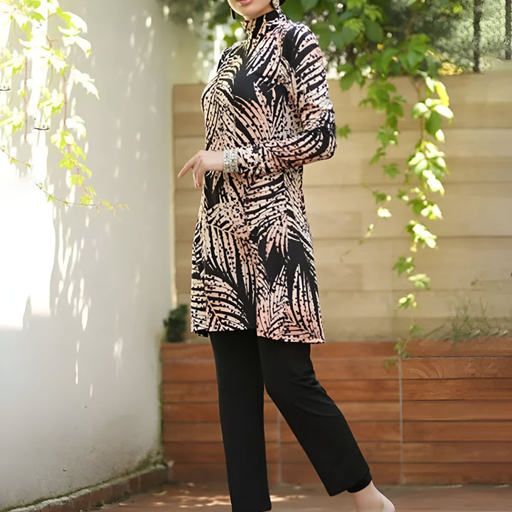 Femme portant un maillot de bain burkini intégral noir à motifs floraux blancs, sortant d'une piscine à l'aide d'une échelle.