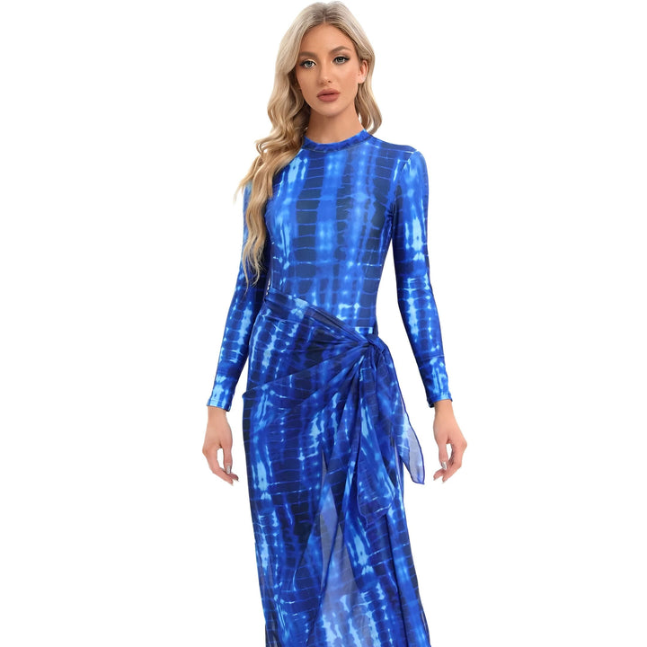 Vue de dos d'une femme portant un maillot de bain intégral bleu à manches longues avec un motif tie-dye et une jupe courte. Une ceinture souligne sa taille.