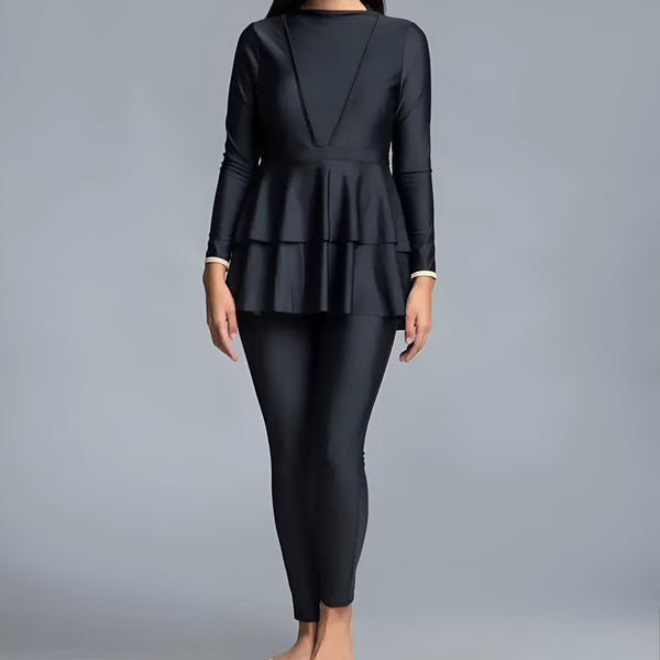Image d'une femme portant un maillot de bain intégral noir avec une jupe à volants, mettant en valeur le style et la couverture du vêtement de bain modeste. Mode de bain pour femmes, vêtements de plage islamiques.
