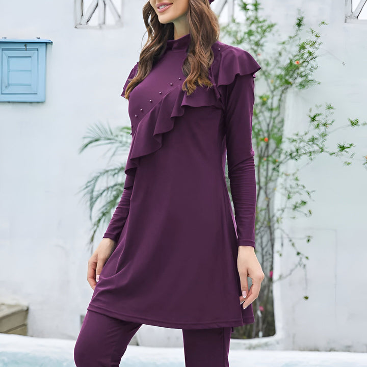 Femme portant un maillot de bain intégral violet avec des volants décoratifs. Vêtements de bain modestes et élégants près de la piscine.