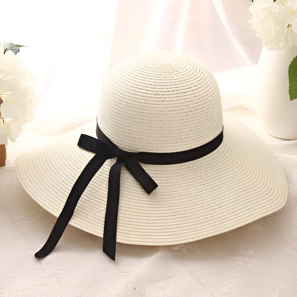 Chapeau de paille beige avec ruban noir, parfait pour l'été et la protection solaire. Élégant et décontracté, idéal pour la plage ou une promenade en ville.