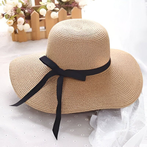 Chapeau de paille blanc avec un ruban noir noué. Accessoire de mode élégant pour l'été, protection solaire avec style.