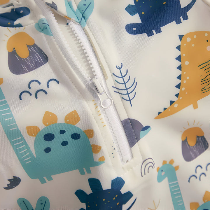 Combinaison de bain pour bébé avec imprimé dinosaures et palmiers. Vêtement d'été pour enfants, fermeture éclair sur le devant. Motif coloré sur fond blanc. Idéal pour la plage et la piscine.