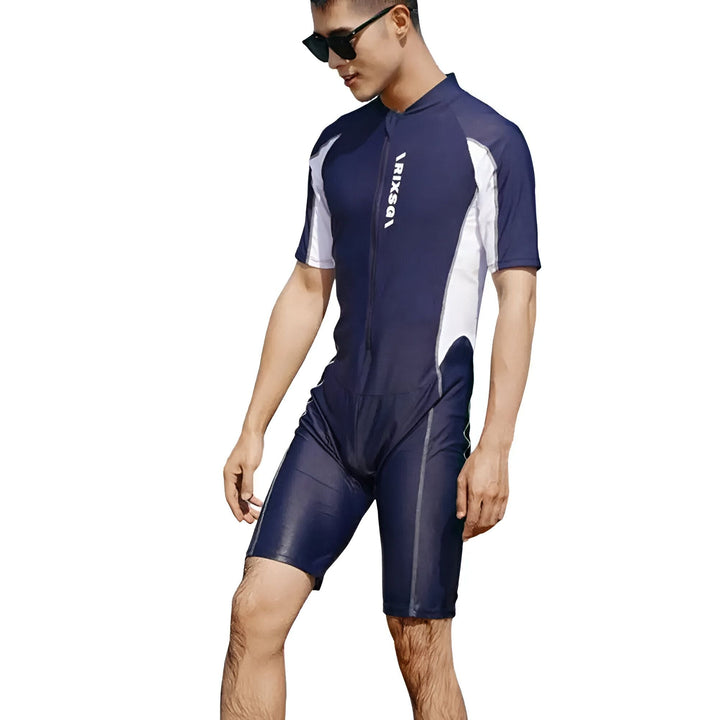 Un homme asiatique portant une combinaison de plongée noire et blanche avec des manches courtes. Il regarde vers la gauche. Vêtement de sport pour la natation et les activités nautiques.