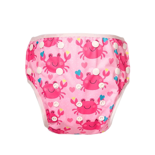 Couche de bain réutilisable rose avec des motifs de crabes roses et blancs, des boutons-pression blancs sur les côtés et une bordure blanche, vue de près et sur fond blanc.