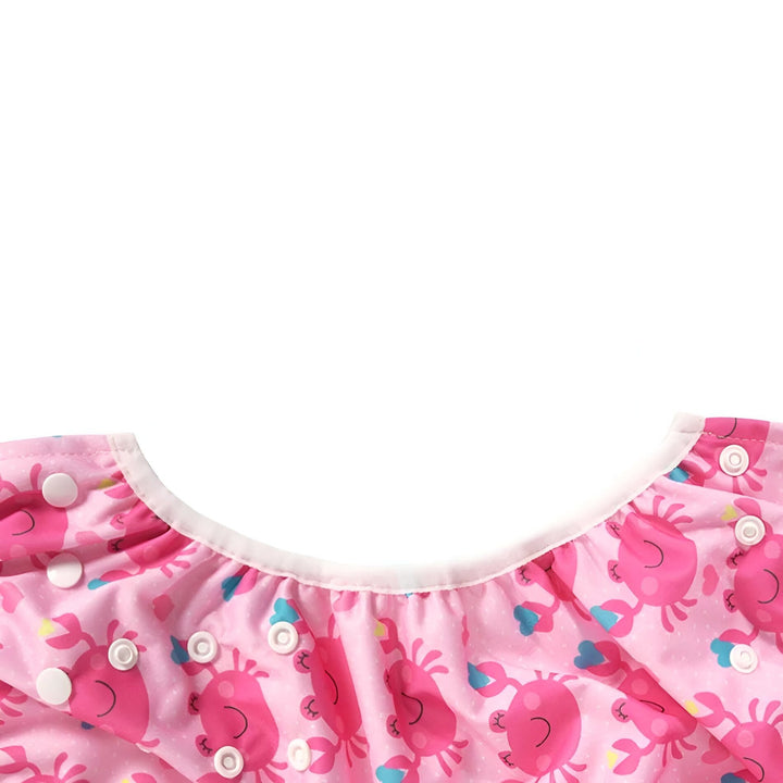 Couche de bain réutilisable rose avec motif de crabes mignons et boutons-pression blancs. Idéale pour bébé, écologique et pratique pour la plage ou la piscine.