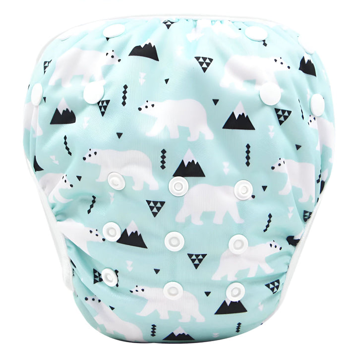 Culotte de bain rose pour bébé, avec des motifs de zèbres, de coeurs et de nœuds. Les bords sont blancs et il y a des boutons-pression blancs sur le côté.