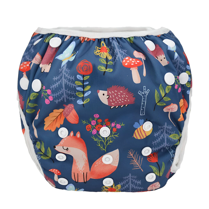 Couche de bain réutilisable pour bébé, motif forêt : renard roux, hérisson mignon, abeille rayée, champignons rouges et végétation variée. Système de fermeture à pressions blanches sur fond bleu marine. Idéale pour la baignade !