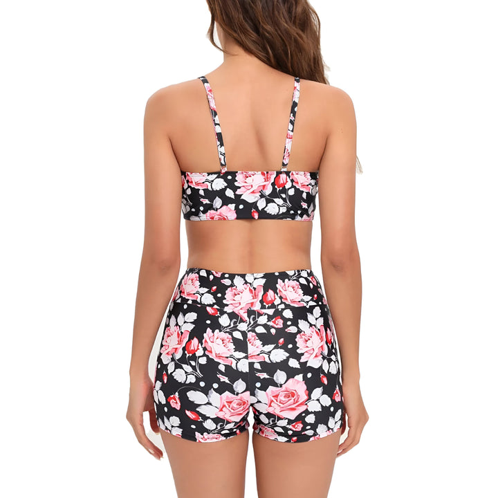 Femme souriante portant un ensemble deux pièces floral bleu et blanc, composé d'un haut de bikini et d'un short de bain, pour la plage ou la piscine. Mode estivale.