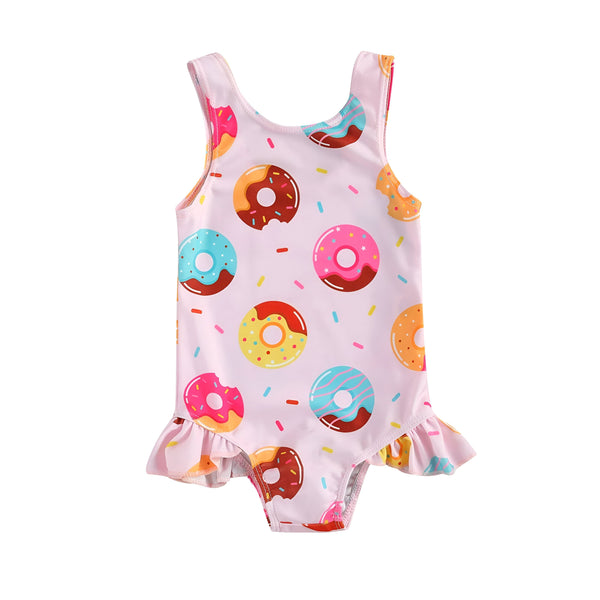 Maillot de bain une pièce rose pour enfant, imprimé avec des motifs de donuts colorés et décoré de petits volants. Idéal pour la plage et la piscine.