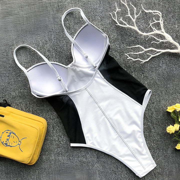Image d'un maillot de bain une pièce blanc et noir avec un sac jaune et des fleurs. Idéal pour la plage ou la piscine. Mode estivale, style élégant.