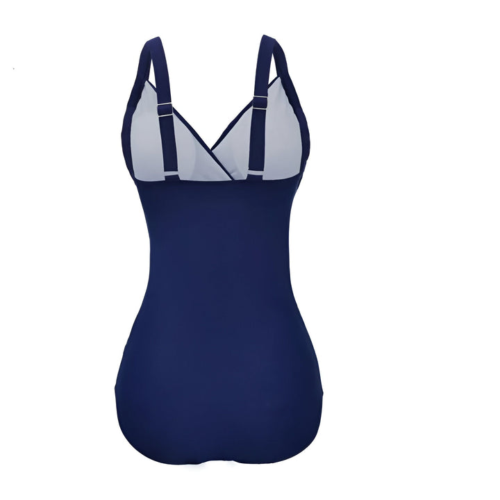 Maillot de bain une pièce bleu marine avec bretelles et découpes en tulle sur les côtés. Design croisé à la taille.