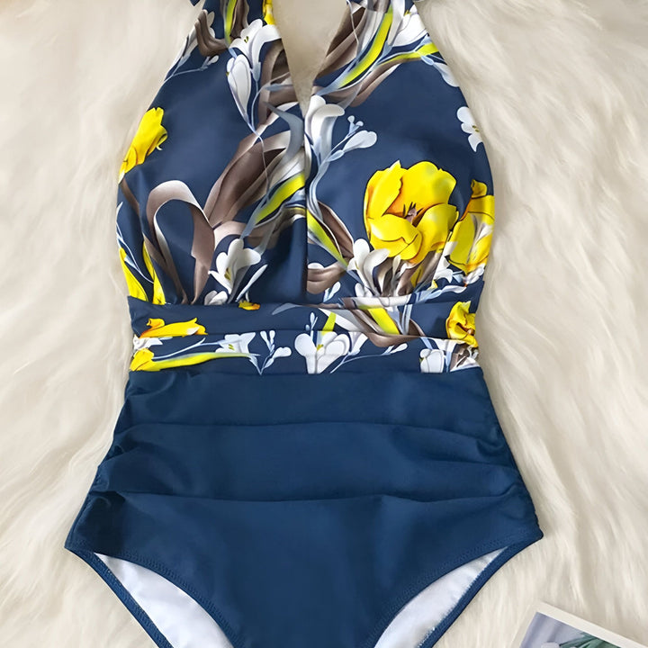 Maillot de bain une pièce bleu marine avec motif floral jaune et blanc sur fond en fausse fourrure blanche.