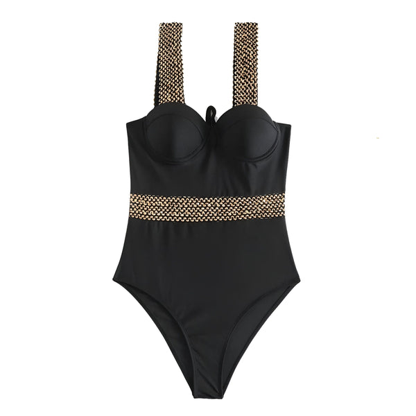 Maillot de bain noir avec bretelles ornées de perles, chapeau de paille et lunettes de soleil sur fond blanc. Accessoires d'été et mode balnéaire.