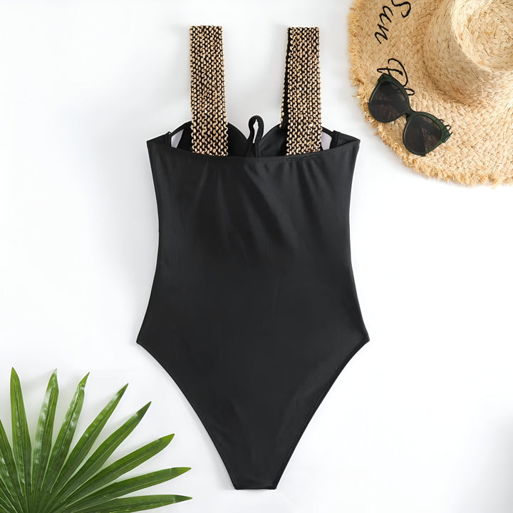 Vue rapprochée d'un maillot de bain noir avec des bretelles dorées. Détails de la couture et du tissu. Mode estivale.