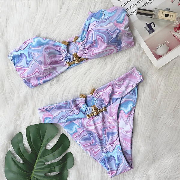 Ensemble de bikini bleu galaxie avec des ornements dorés, posé sur une fourrure blanche. Style tendance, parfait pour l'été et la plage.