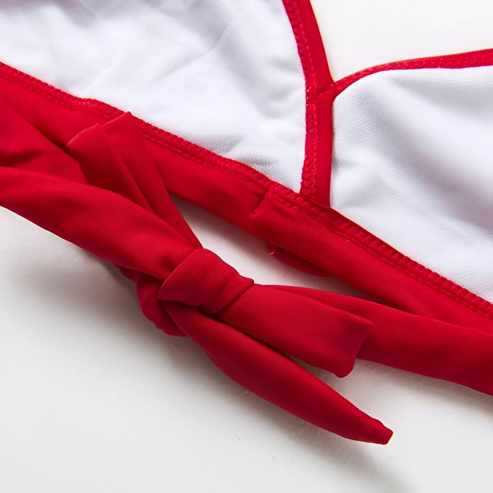 Détail d'un haut de bikini rouge et blanc avec des bretelles à nouer. Tissu doux et texturé. Idéal pour la plage ou la piscine.