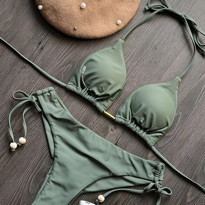 Image d'un bikini deux pièces vert citron tendance sur un fond en bois foncé, mettant en valeur un style estival et moderne.