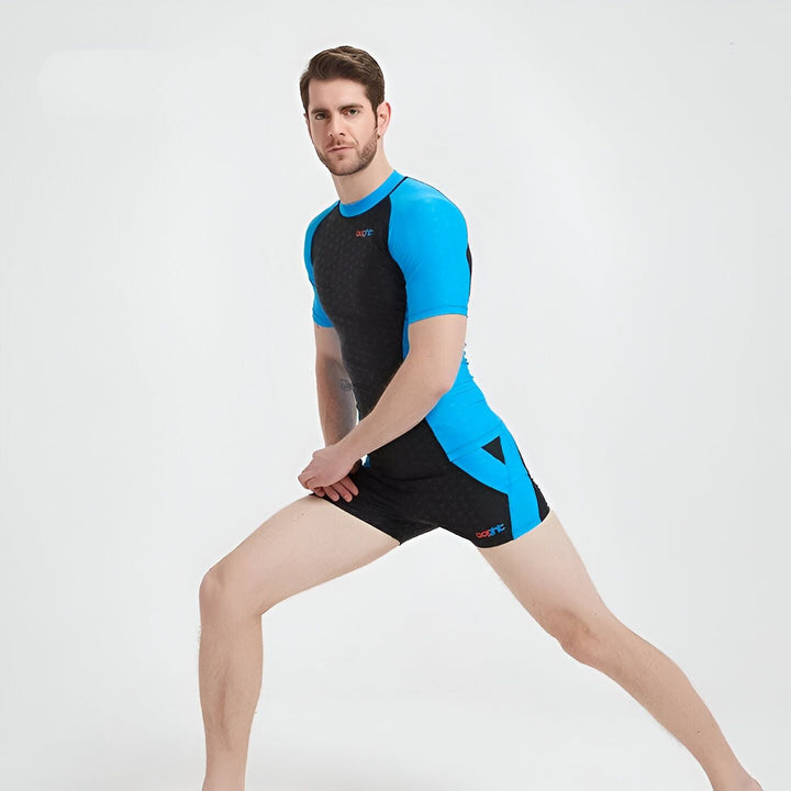 Homme vu de dos portant un ensemble de natation bleu et noir avec un motif subtil.