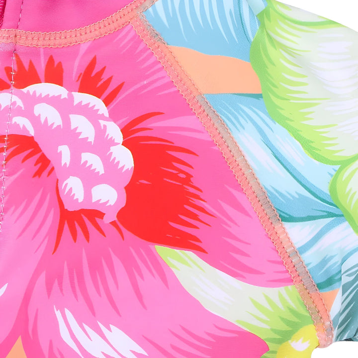 Combinaison de bain pour bébé avec motif floral coloré, manches longues et col rose. Idéale pour la plage et la piscine, protège du soleil avec style.
