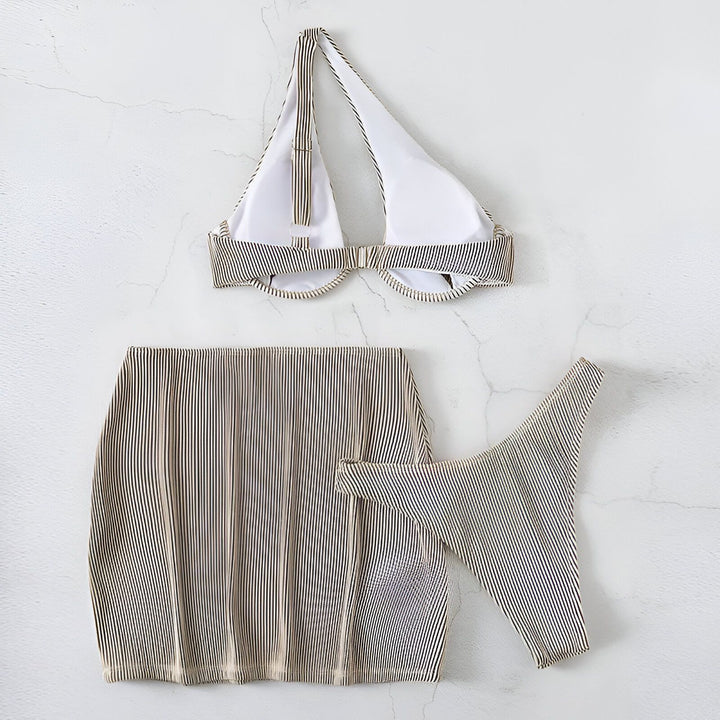 Gros plan d'une femme portant un ensemble coordonné violet : haut de bikini asymétrique et mini-jupe côtelée. Détails sur la texture du tissu et la silhouette.