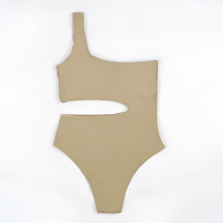 Maillot de bain une pièce beige, une épaule, avec découpe latérale sur fond blanc. Élégant, moderne et parfait pour la plage.