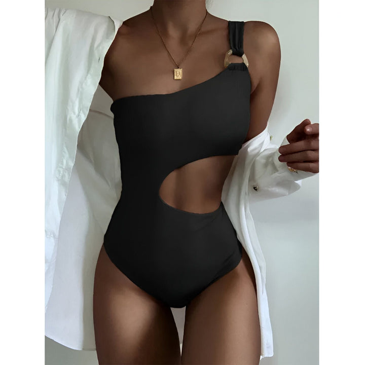 Maillot de bain une pièce beige avec découpe latérale, chapeau de paille et lunettes de soleil. Style estival et tendance pour la plage.
