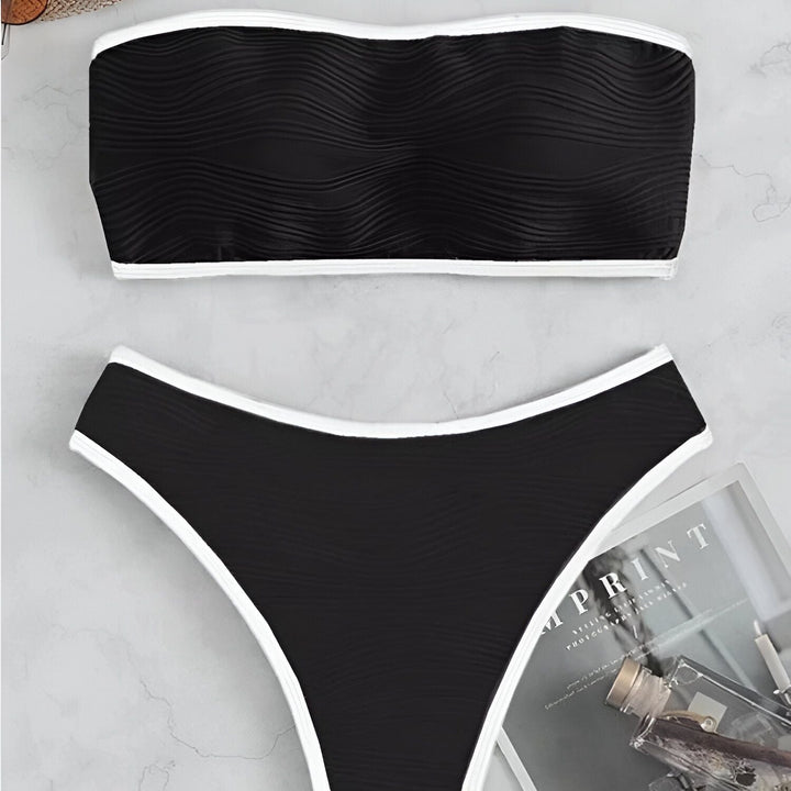 Ensemble de bikini noir à bordure blanche. Haut bandeau texturé et culotte taille haute assortie. Style moderne et élégant.