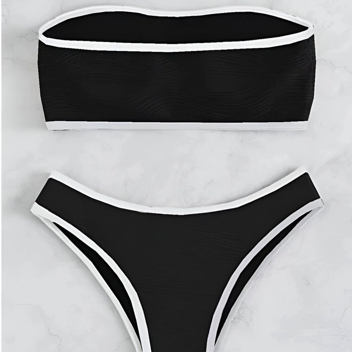 Vue rapprochée d'un bikini beige texturé avec des bordures marron, comprenant un haut bandeau et une culotte assortie. Idéal pour la plage ou la piscine.